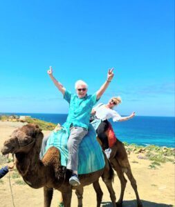 Tangier day tour customers having fun on camel ride on the beach