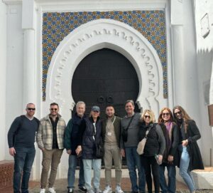 Omar and happy clients in front of magnificent arched door