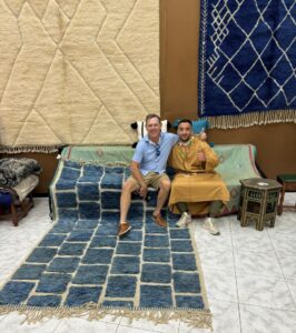 Omar and happy client seated on Handmade rug merchant